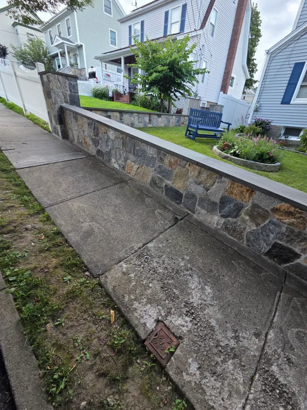 stone-retaining-wall-concrete-walkway.webp
